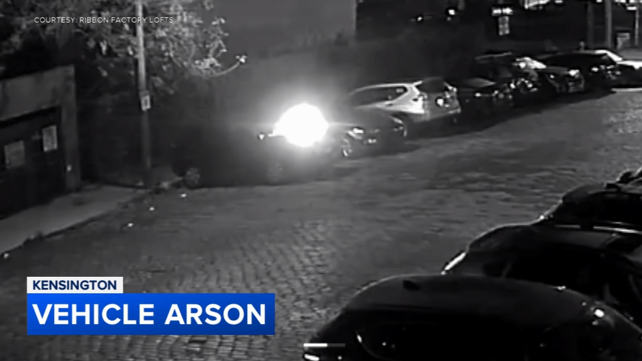 A car engulfed in flames in Kensington, Philadelphia during an arson incident.
